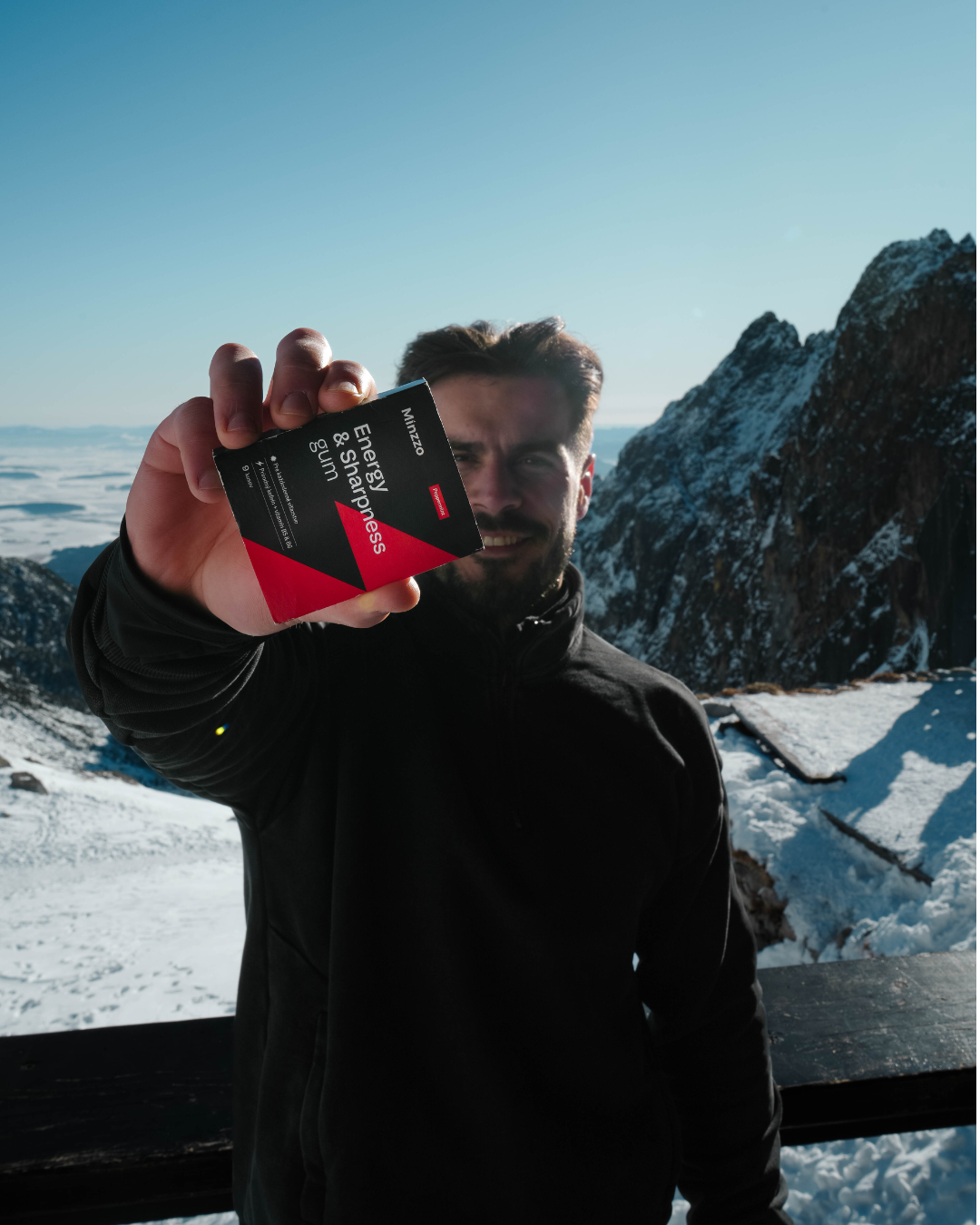 Muž držiaci balenie Minzzo Energy & Sharpness gum v horách